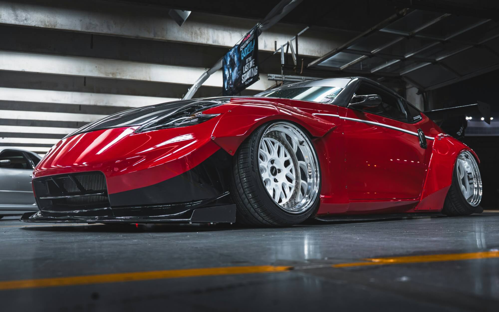 A picture of a red sports car in a parking garage.