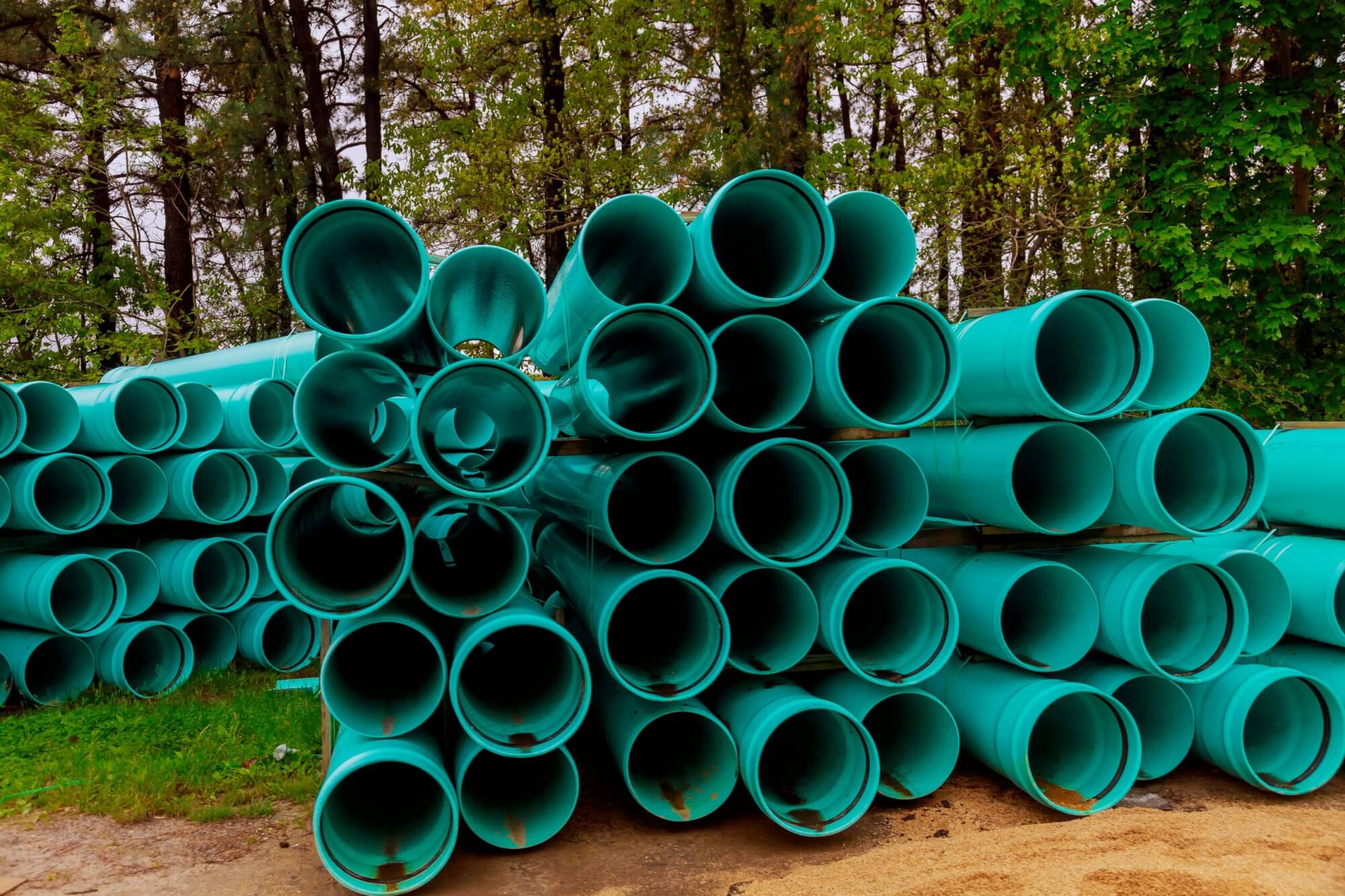 Blue wastewater tubes that are waiting to be installed outdoors.