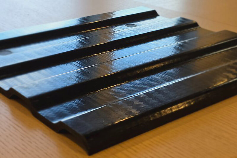 Material that was made by comolding a continuous sheet of SMC material and a continuous glass reinforcement called QISO.