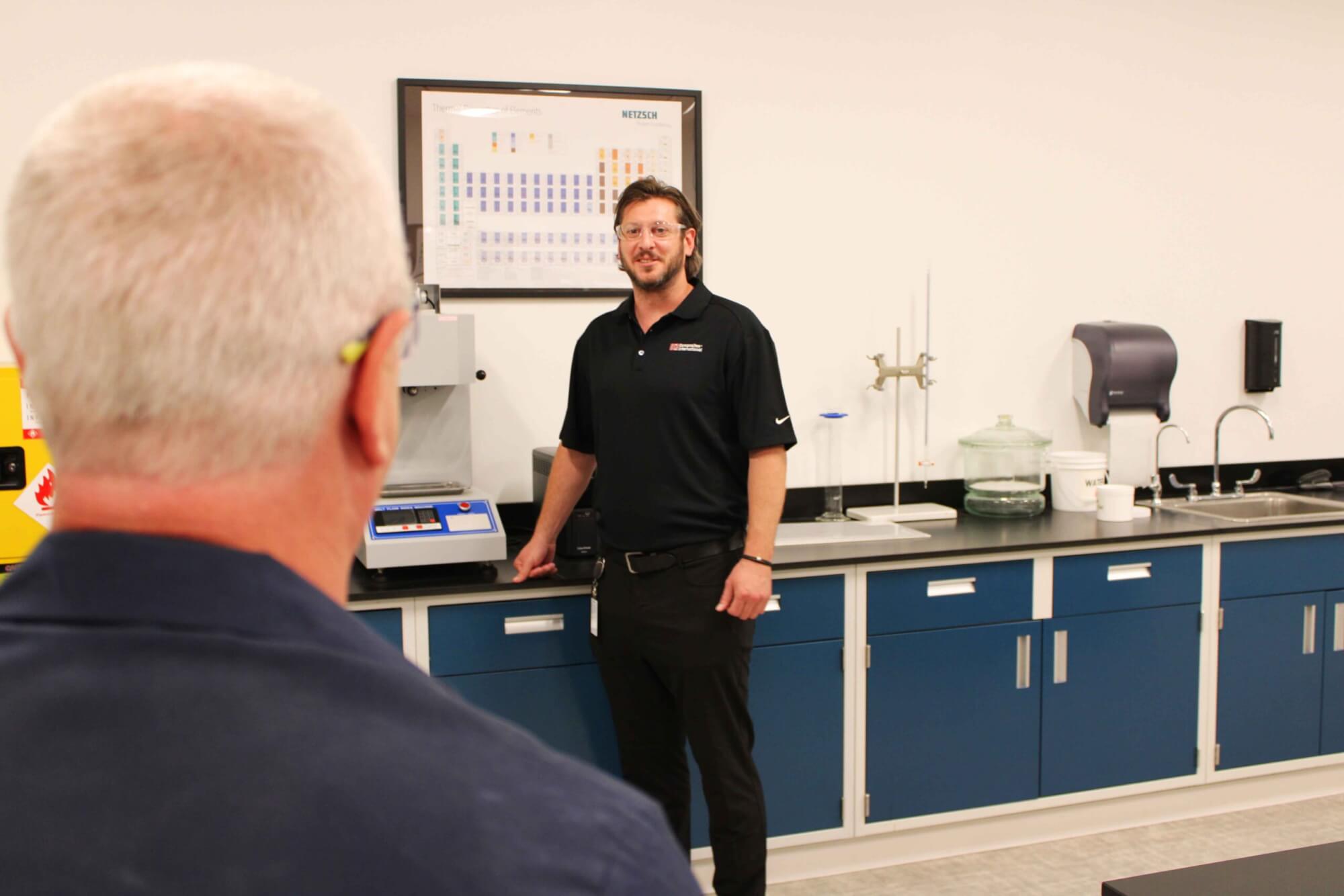 A picture of two people in a lab looking at each other.