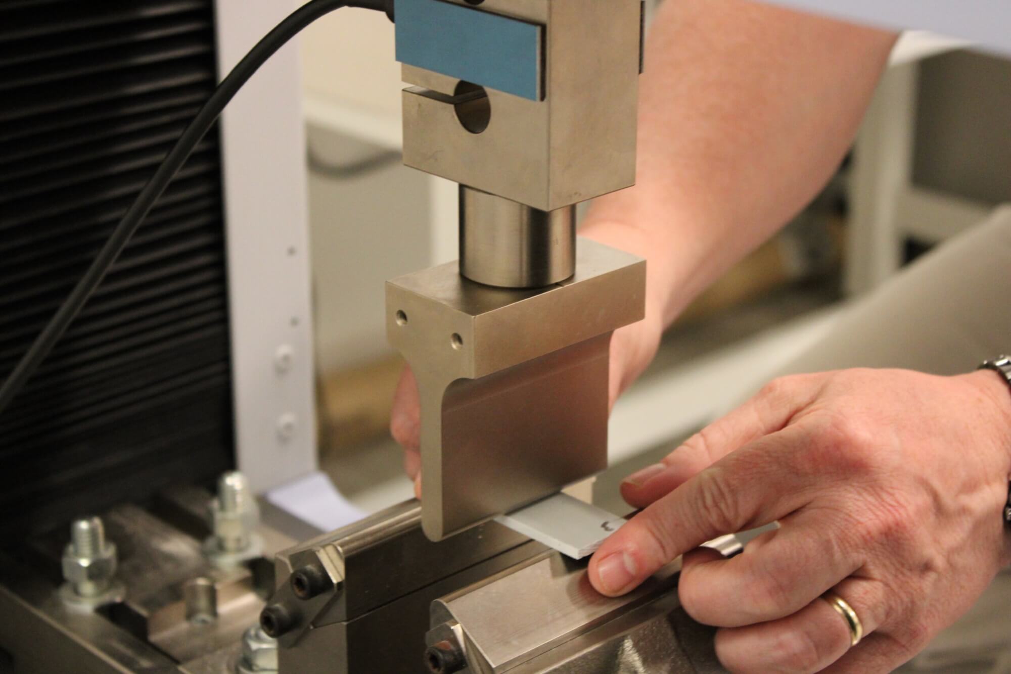 Closeup shot of a person's hands placing a material into a test apparatus.