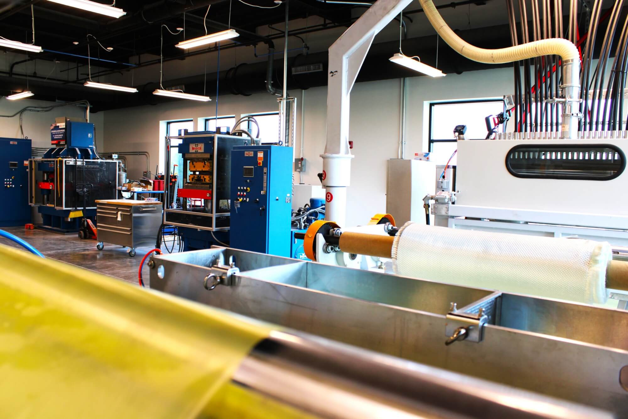 A wide angle from behind a SMC machine research line with two different presses in the background.