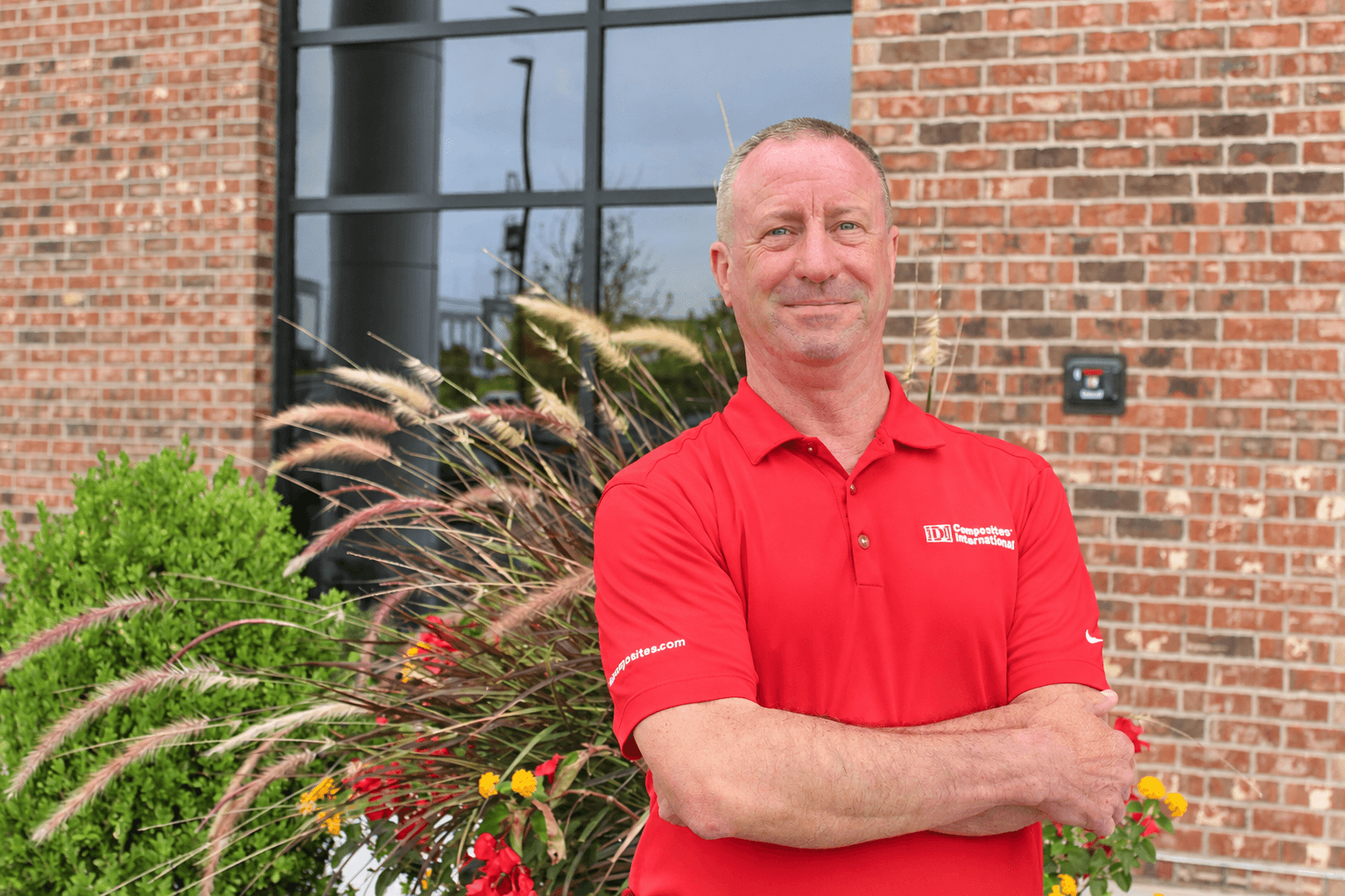 A man standing in front of a planter at a building.