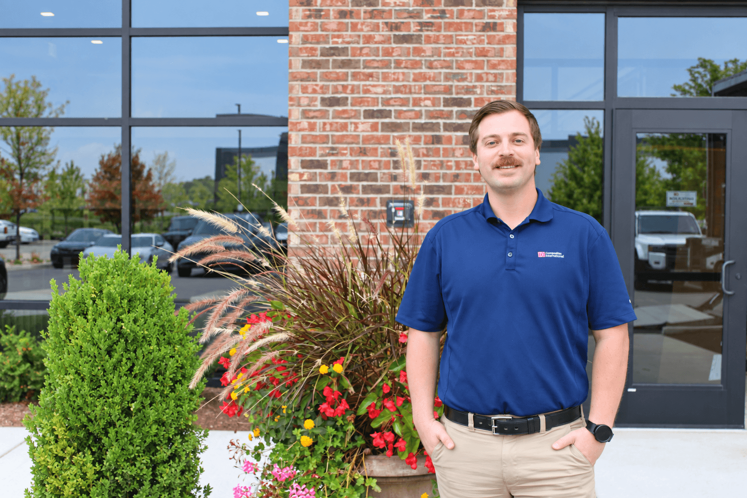 A man standing in front of a planter at a building.