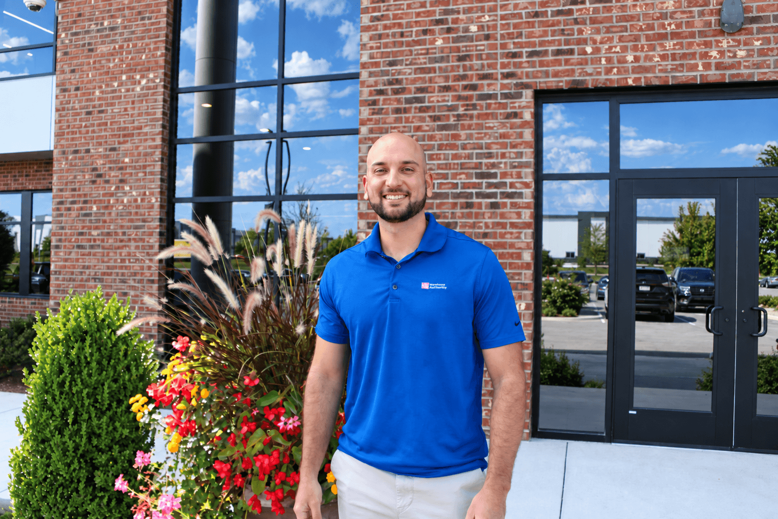 A man standing in front of a planter at a building.