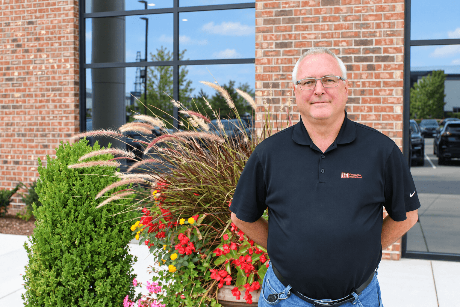 A man standing in front of a planter at a building.